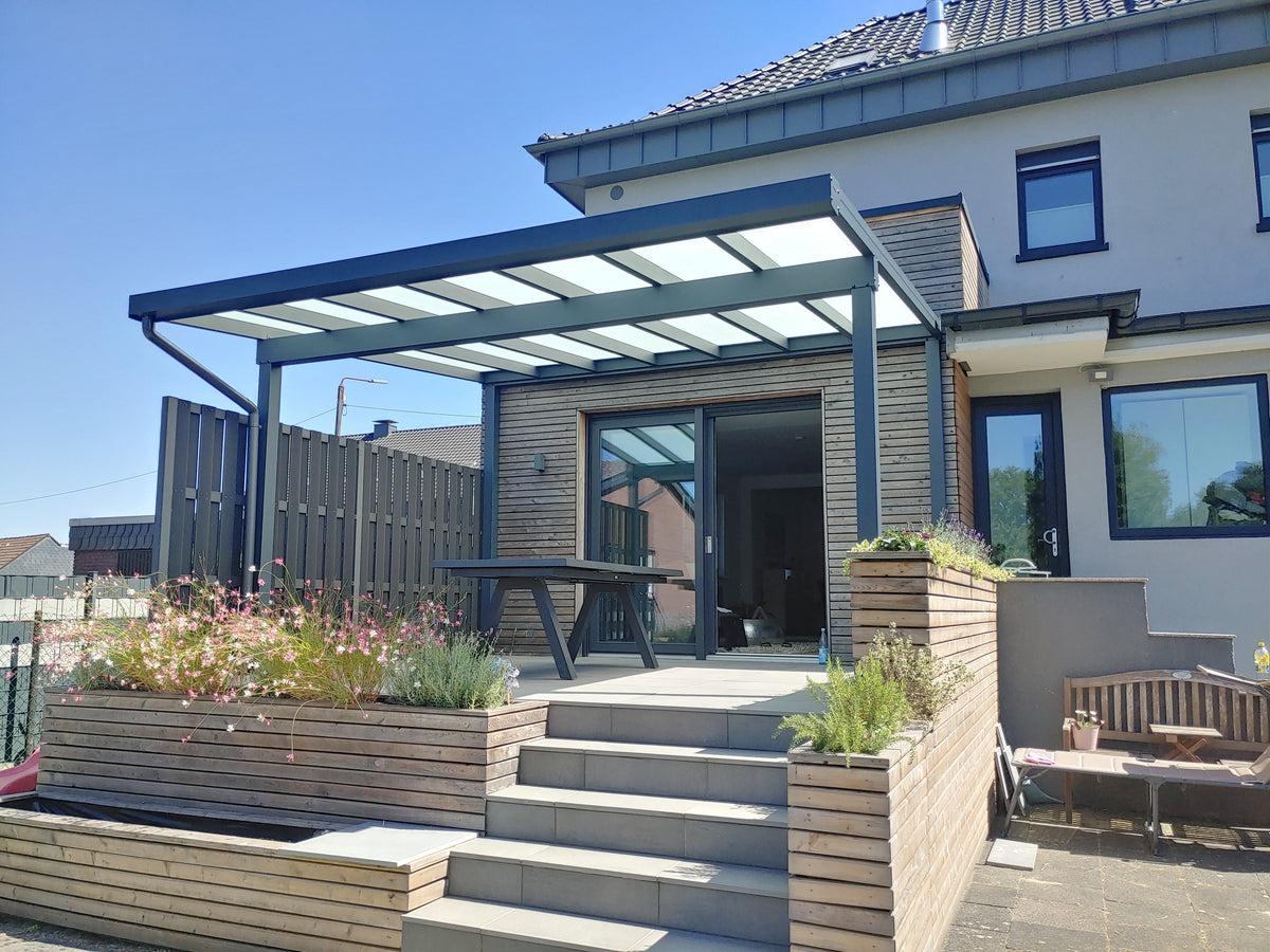 Terrassenüberdachung aus Aluminium an einem Einfamilienhaus mit Holzpflanzkästen